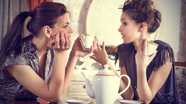 Two-pretty-girl-friends-talk-and-drink-tea-in-drawing-room