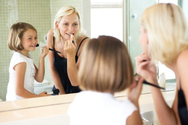 Mother and daughter putting on make-up